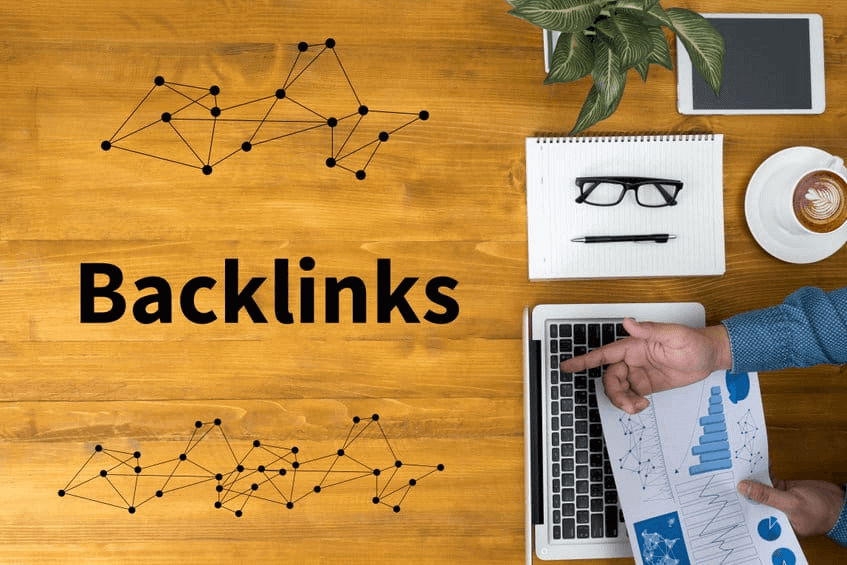 Un professionnel du marketing digital analysant des graphiques sur un ordinateur portable, avec le mot "Backlinks" affiché sur une table en bois, symbolisant les connexions SEO.