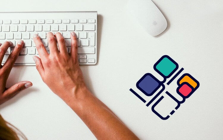 Mains tapant sur un clavier blanc avec une souris blanche à côté, accompagnées d'un logo coloré représentant une collaboration numérique.