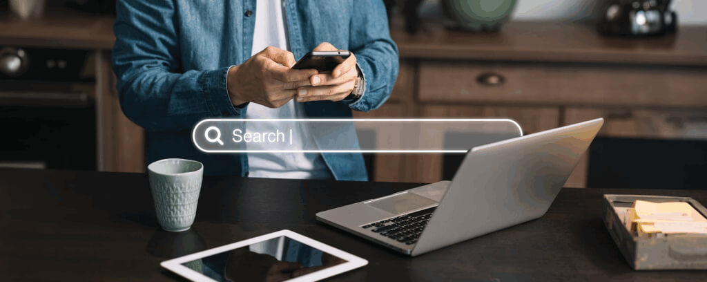 L’image présente un bureau moderne en hauteur. Au centre, un ordinateur portable ouvert. Autour, on aperçoit la barre de recherche google qui signifie le SEO pour les professions libérales au Maroc.